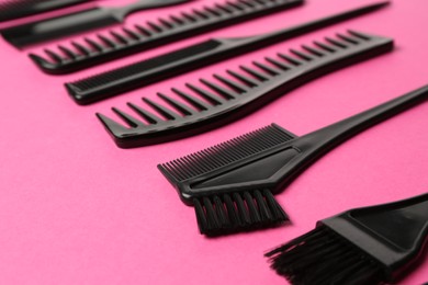 Photo of Different hairdresser's tools on pink background, closeup
