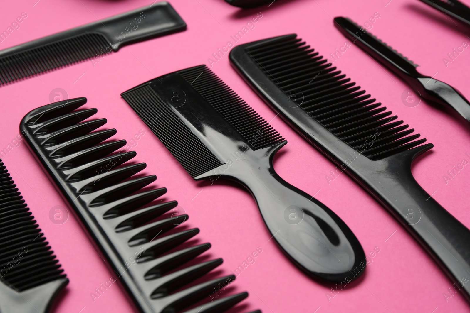 Photo of Different hairdresser's tools on pink background, closeup