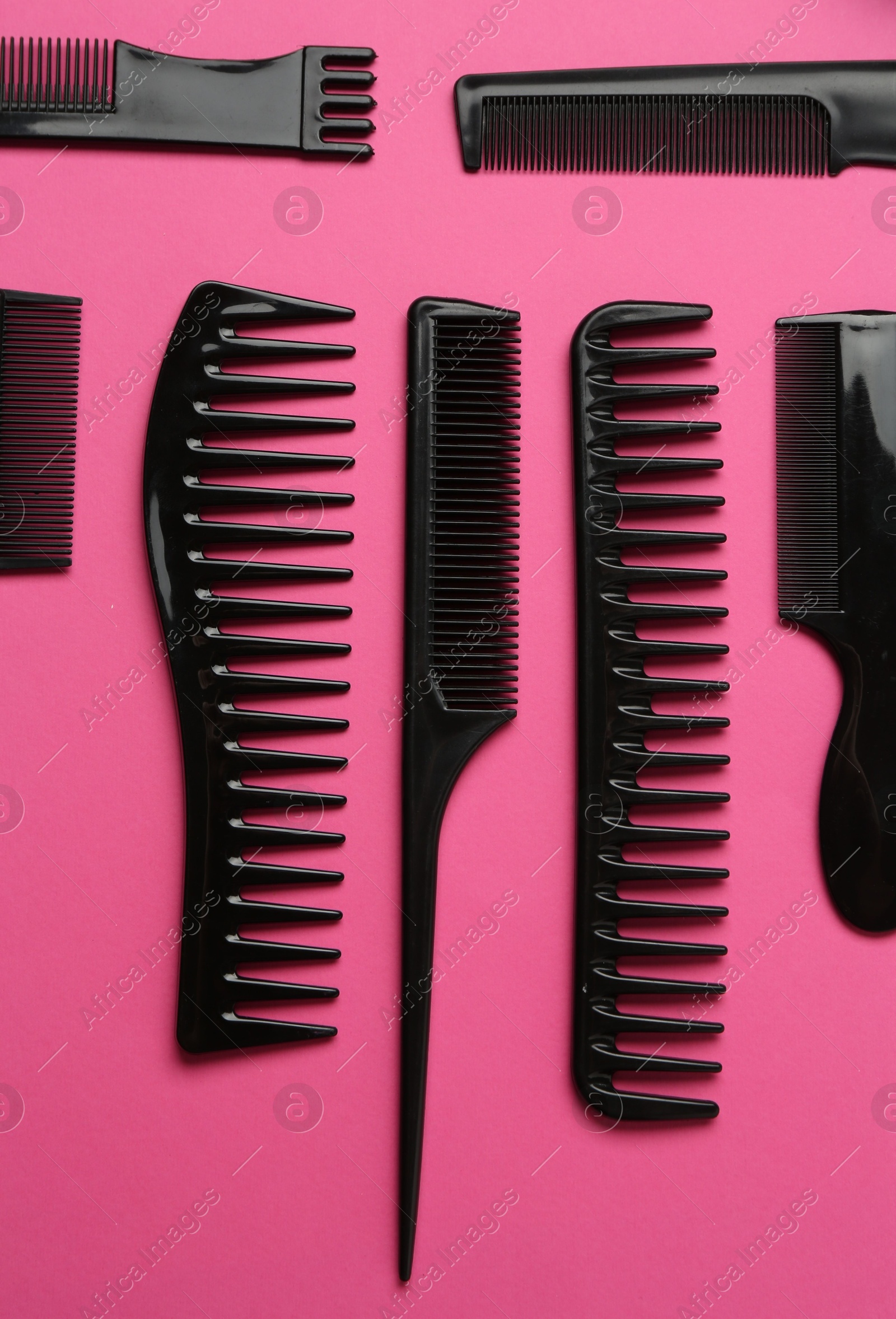 Photo of Different hairdresser's tools on pink background, flat lay