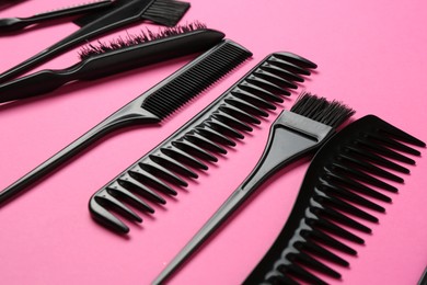 Photo of Different hairdresser's tools on pink background, closeup