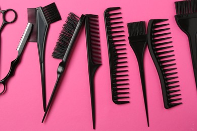 Photo of Different hairdresser's tools on pink background, flat lay
