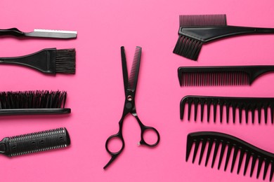 Photo of Different hairdresser's tools on pink background, flat lay