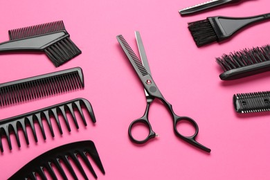 Photo of Different hairdresser's tools on pink background, above view