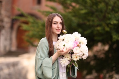 Photo of Charming woman with bouquet of beautiful peonies on city street