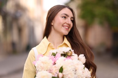 Photo of Woman with bouquet of beautiful peonies on city street