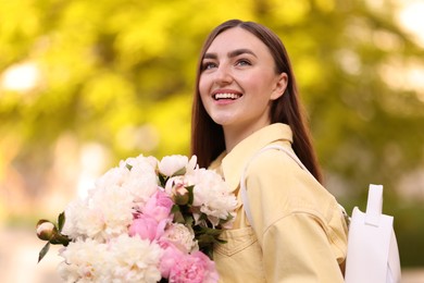 Photo of Woman with bouquet of beautiful peonies on city street