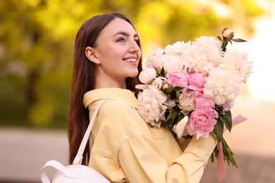 Photo of Woman with bouquet of beautiful peonies on city street