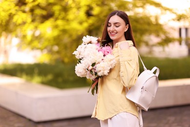 Photo of Woman with bouquet of beautiful peonies on city street