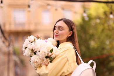 Photo of Woman with bouquet of beautiful peonies on city street