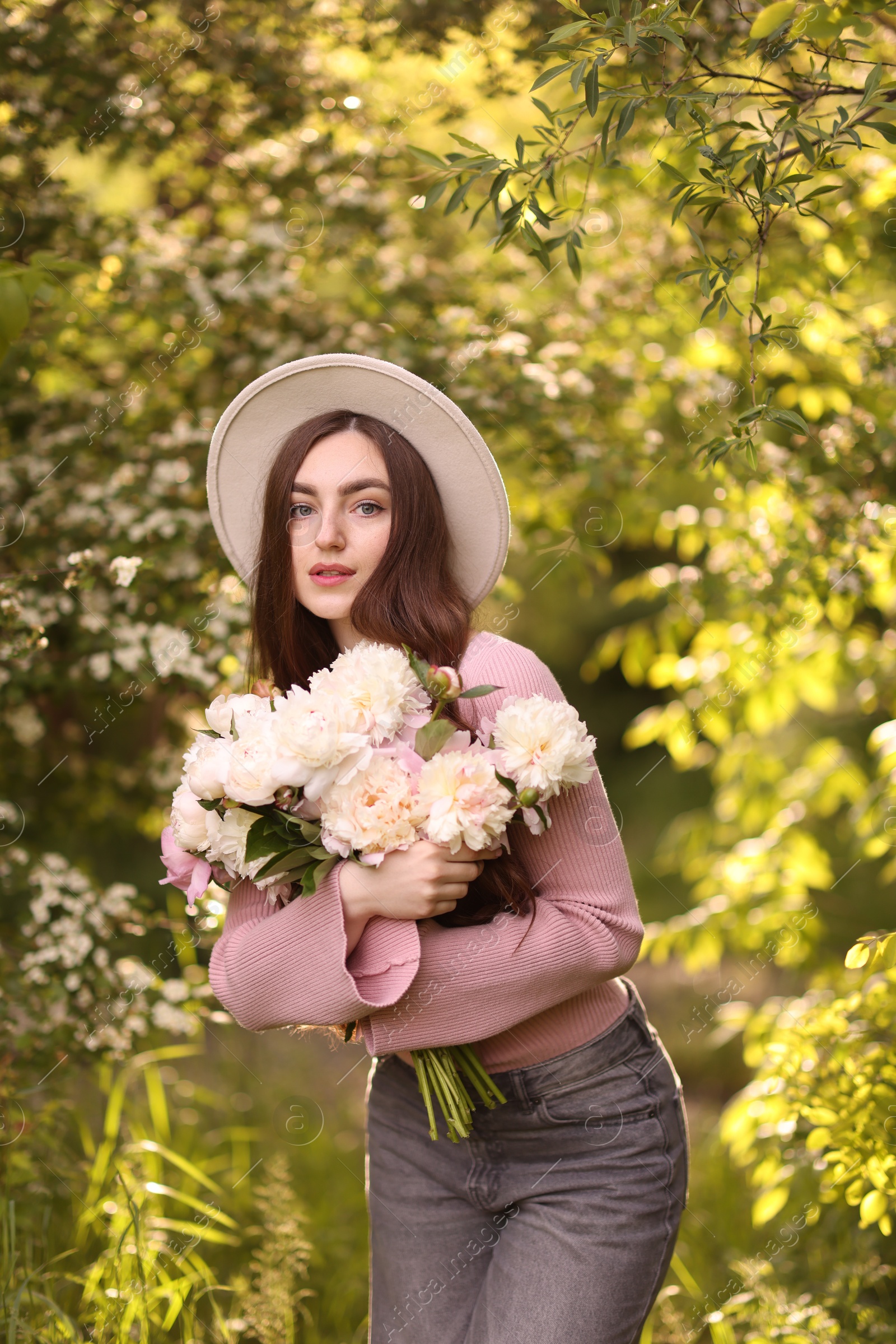 Beautiful woman with bouquet of peonies in park Photo of Beautiful woman with bouquet of peonies in park