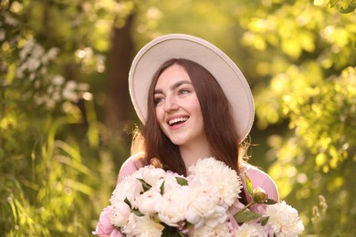 Photo of Beautiful woman with bouquet of peonies in park