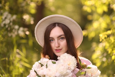 Photo of Beautiful woman with bouquet of peonies in park