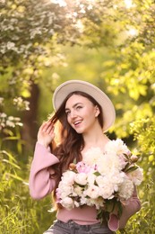 Photo of Beautiful woman with bouquet of peonies in park