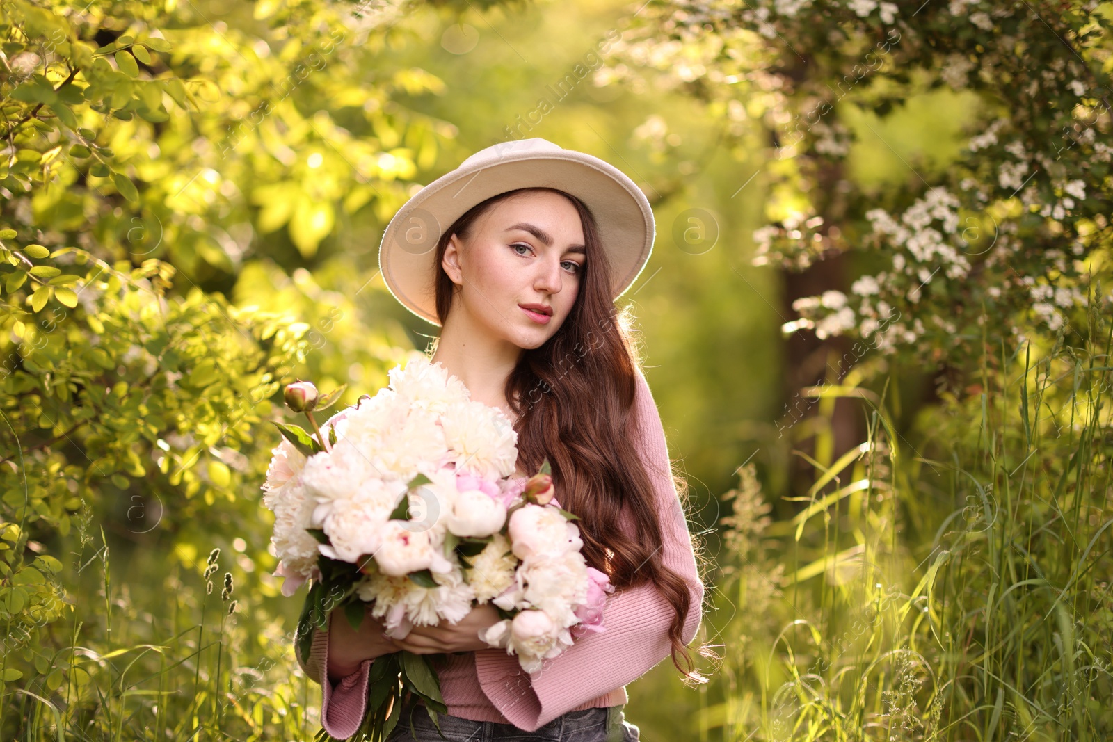 Photo of Beautiful woman with bouquet of peonies in park
