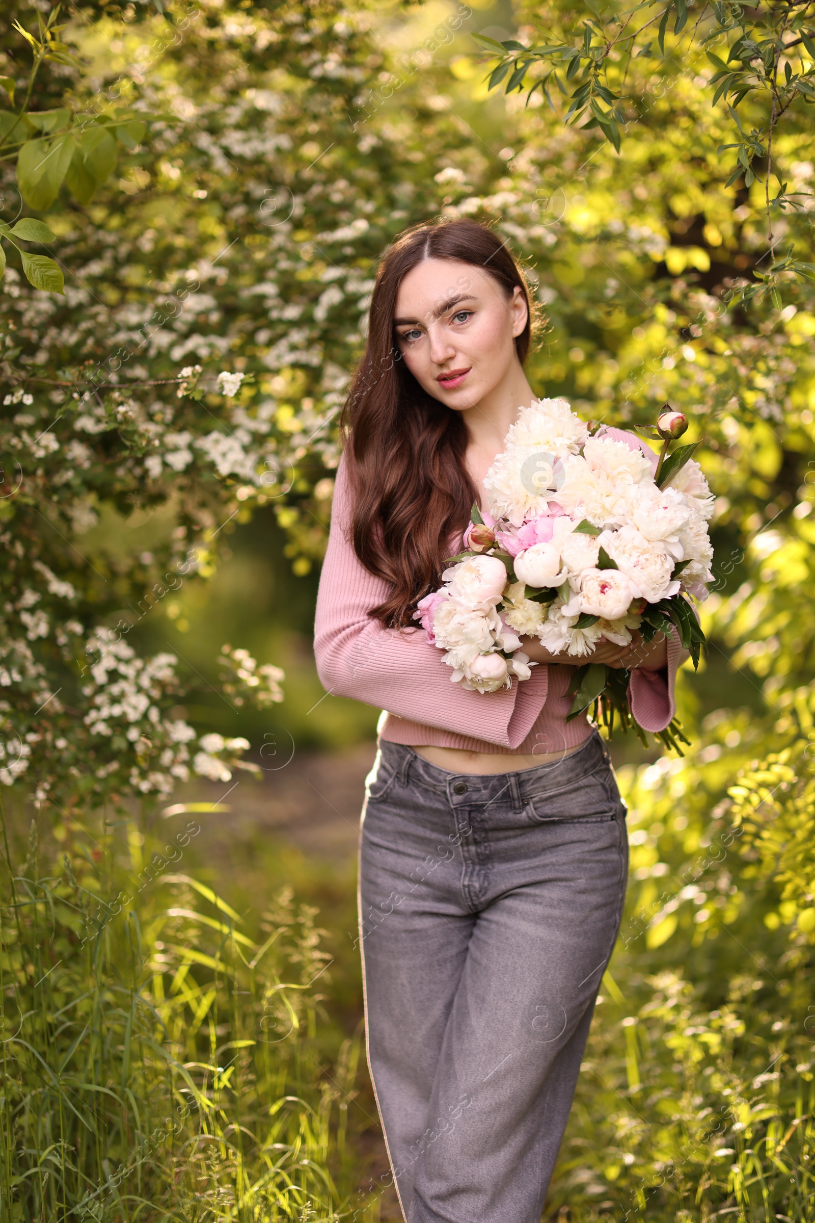 Photo of Beautiful woman with bouquet of peonies in park