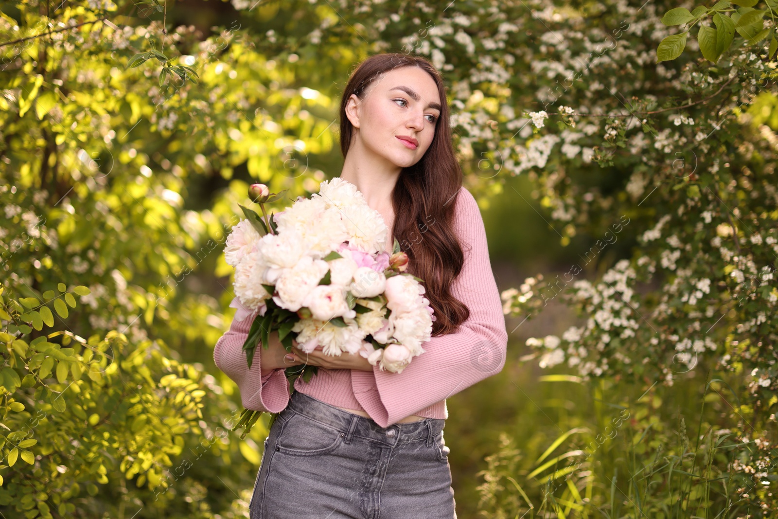 Photo of Beautiful woman with bouquet of peonies in park