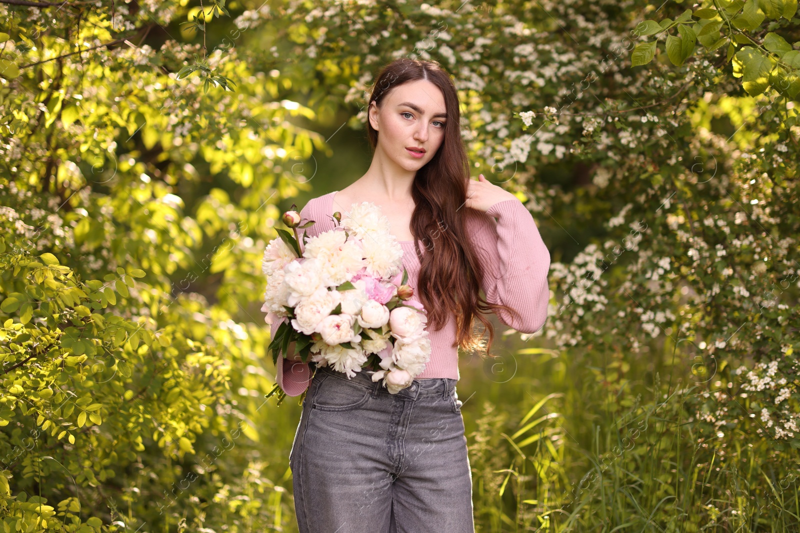 Photo of Beautiful woman with bouquet of peonies in park