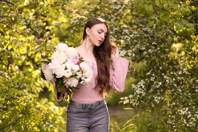 Photo of Beautiful woman with bouquet of peonies in park