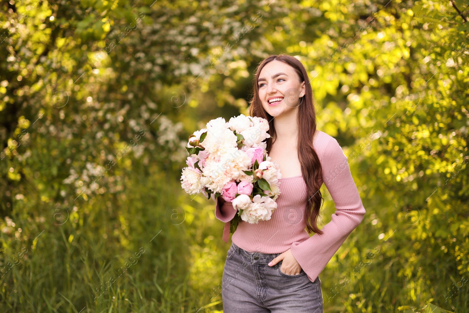 Beautiful woman with bouquet of peonies in park. Space for text Photo of Beautiful woman with bouquet of peonies in park. Space for text