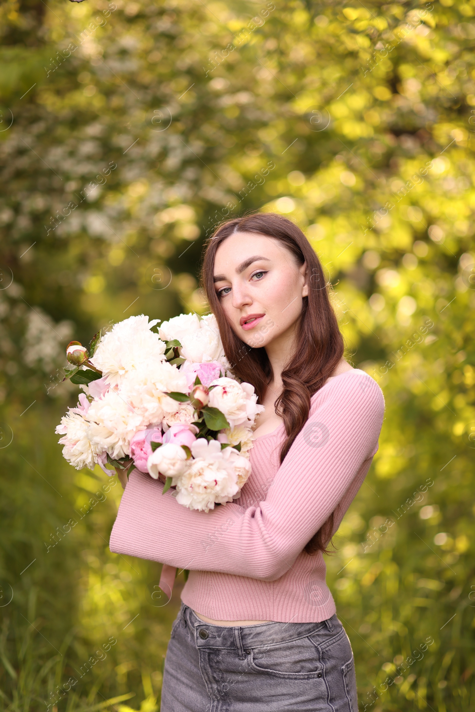 Photo of Beautiful woman with bouquet of peonies in park