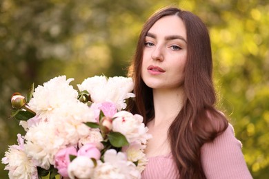 Photo of Beautiful woman with bouquet of peonies in park