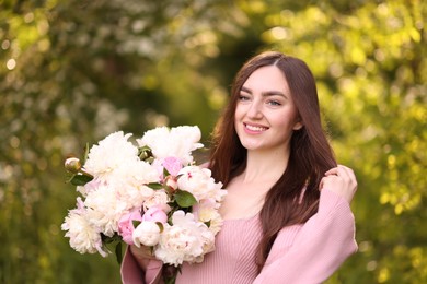 Photo of Beautiful woman with bouquet of peonies in park