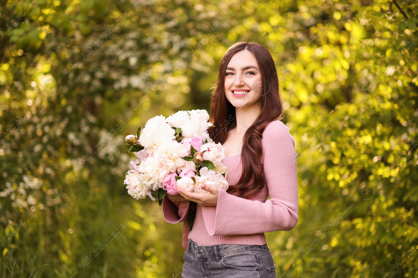 Photo of Beautiful woman with bouquet of peonies in park