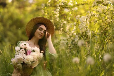 Photo of Beautiful woman with bouquet of peonies in park. Space for text