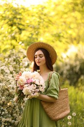 Photo of Beautiful woman with bouquet of peonies in park