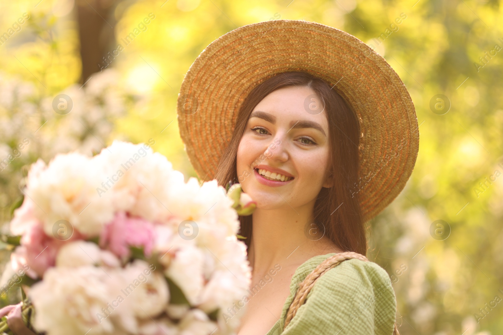 Beautiful woman with bouquet of peonies in park on sunny day Photo of Beautiful woman with bouquet of peonies in park on sunny day