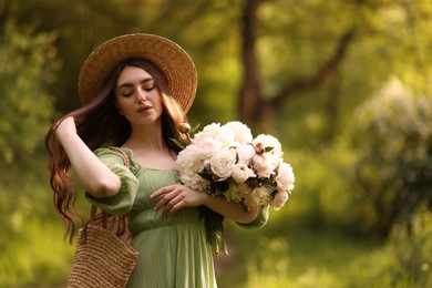 Photo of Beautiful woman with bouquet of peonies in park. Space for text