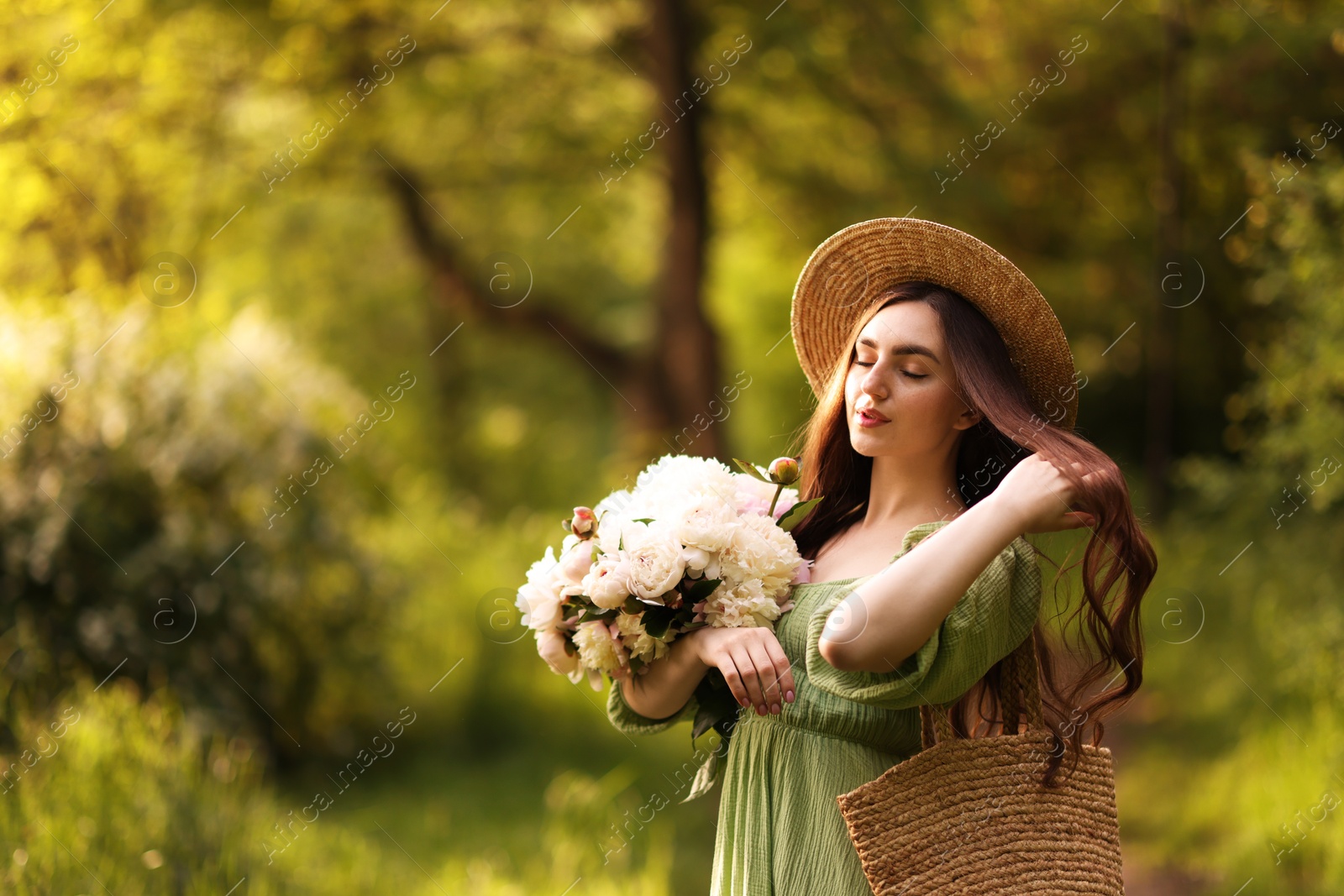 Beautiful woman with bouquet of peonies in park. Space for text Photo of Beautiful woman with bouquet of peonies in park. Space for text