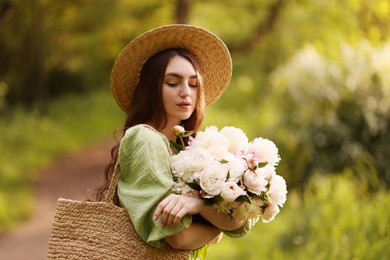Photo of Beautiful woman with bouquet of peonies in park