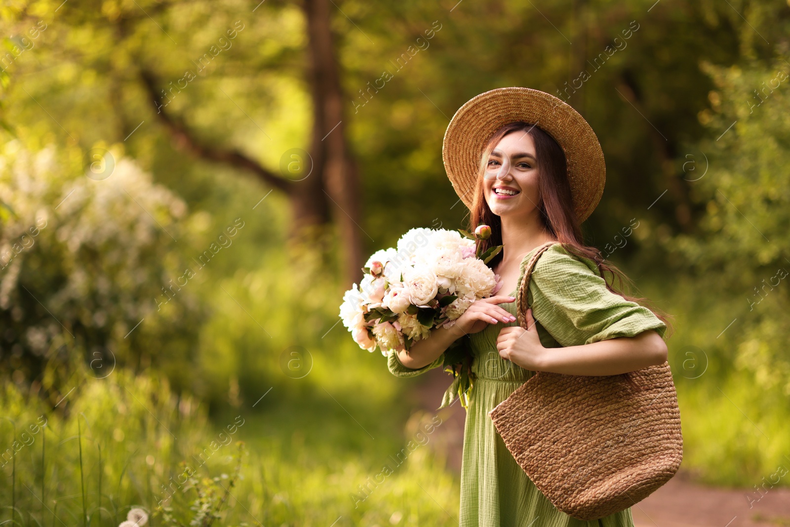 Beautiful woman with bouquet of peonies in park. Space for text Photo of Beautiful woman with bouquet of peonies in park. Space for text