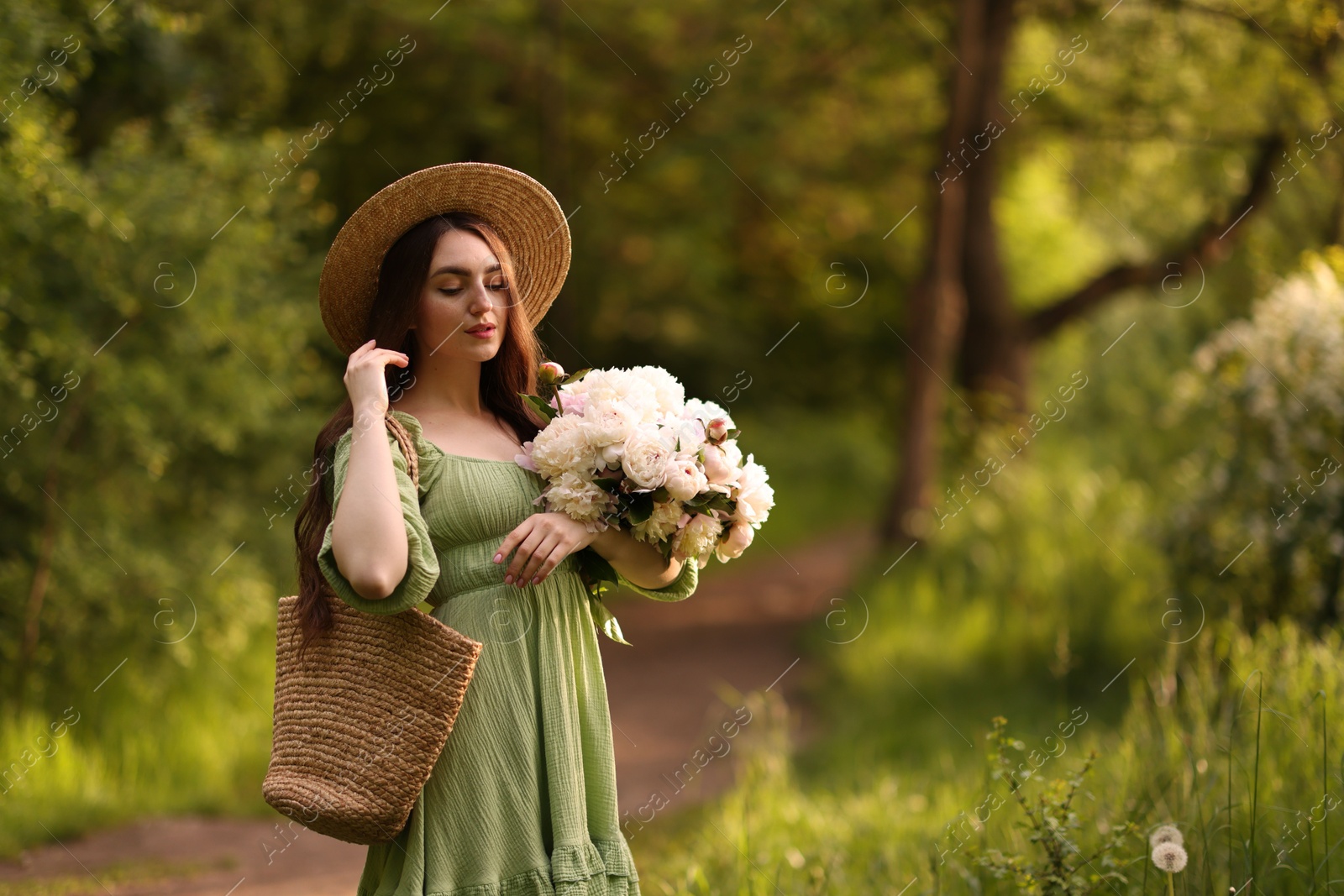 Beautiful woman with bouquet of peonies in park. Space for text Photo of Beautiful woman with bouquet of peonies in park. Space for text