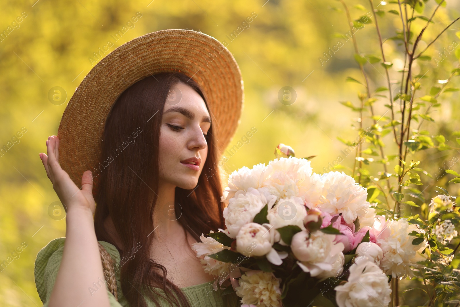 Beautiful woman with bouquet of peonies in park Photo of Beautiful woman with bouquet of peonies in park
