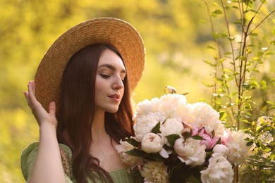 Photo of Beautiful woman with bouquet of peonies in park