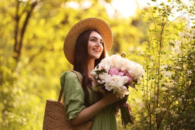 Photo of Beautiful woman with bouquet of peonies in park