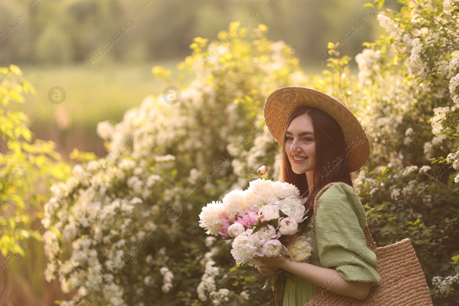 Beautiful woman with bouquet of peonies in park on sunny day. Space for text Photo of Beautiful woman with bouquet of peonies in park on sunny day. Space for text