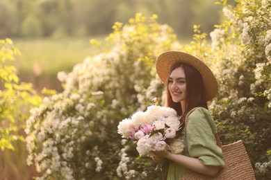 Photo of Beautiful woman with bouquet of peonies in park on sunny day. Space for text