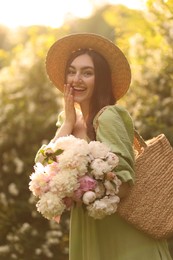 Photo of Beautiful woman with bouquet of peonies in park on sunny day