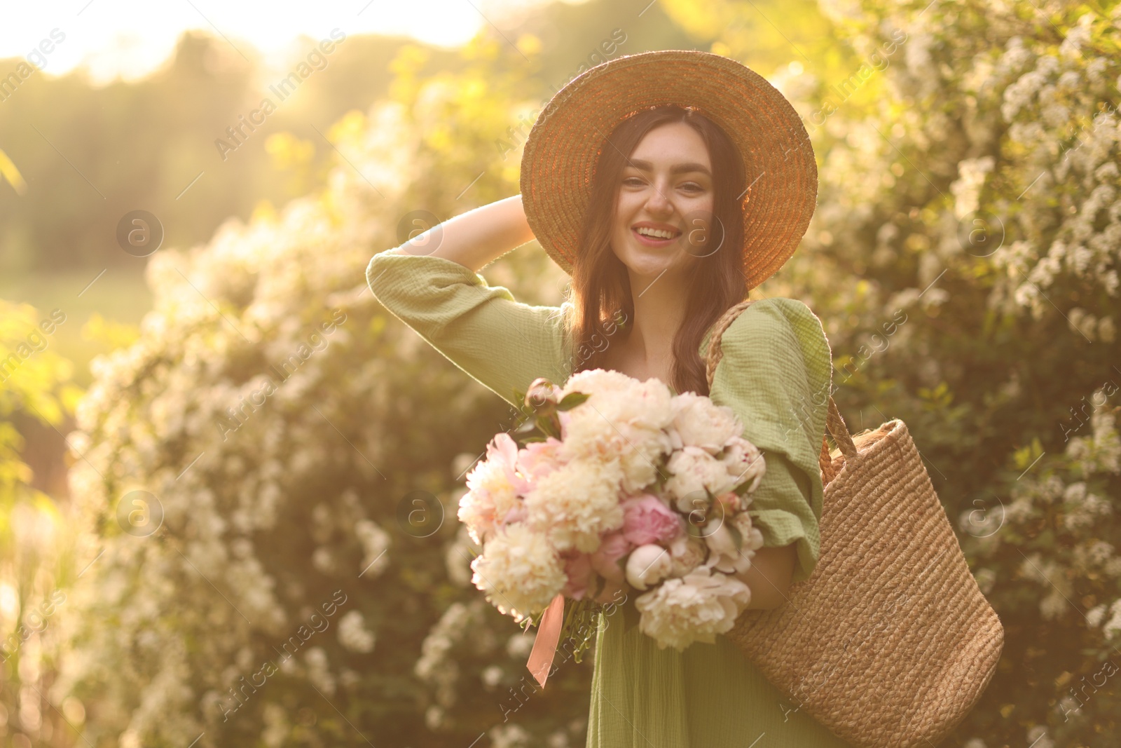 Beautiful woman with bouquet of peonies in park on sunny day. Space for text Photo of Beautiful woman with bouquet of peonies in park on sunny day. Space for text