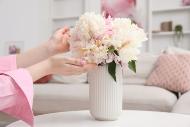 Photo of Woman with bouquet of beautiful peonies at home, closeup