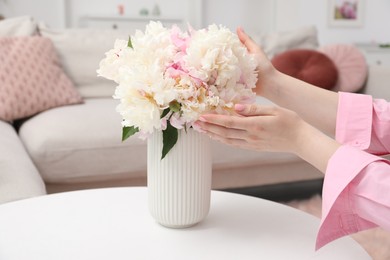 Photo of Woman with bouquet of beautiful peonies at home, closeup