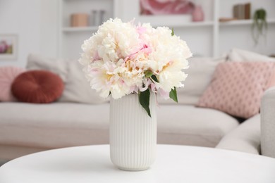 Photo of Bouquet of beautiful peonies on table indoors