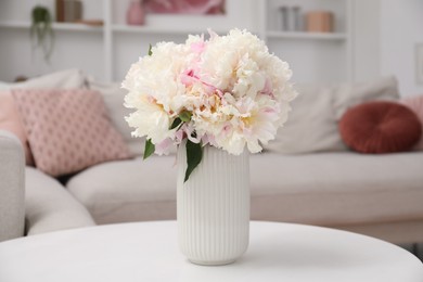 Photo of Bouquet of beautiful peonies on table indoors