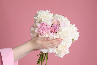 Photo of Woman with bouquet of beautiful peonies on pink background, closeup