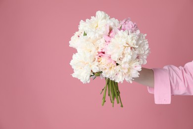 Photo of Woman with bouquet of beautiful peonies on pink background, closeup. Space for text