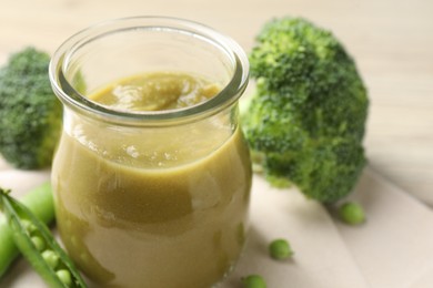 Photo of Baby food. Tasty puree in glass jar and ingredients on table, closeup. Space for text