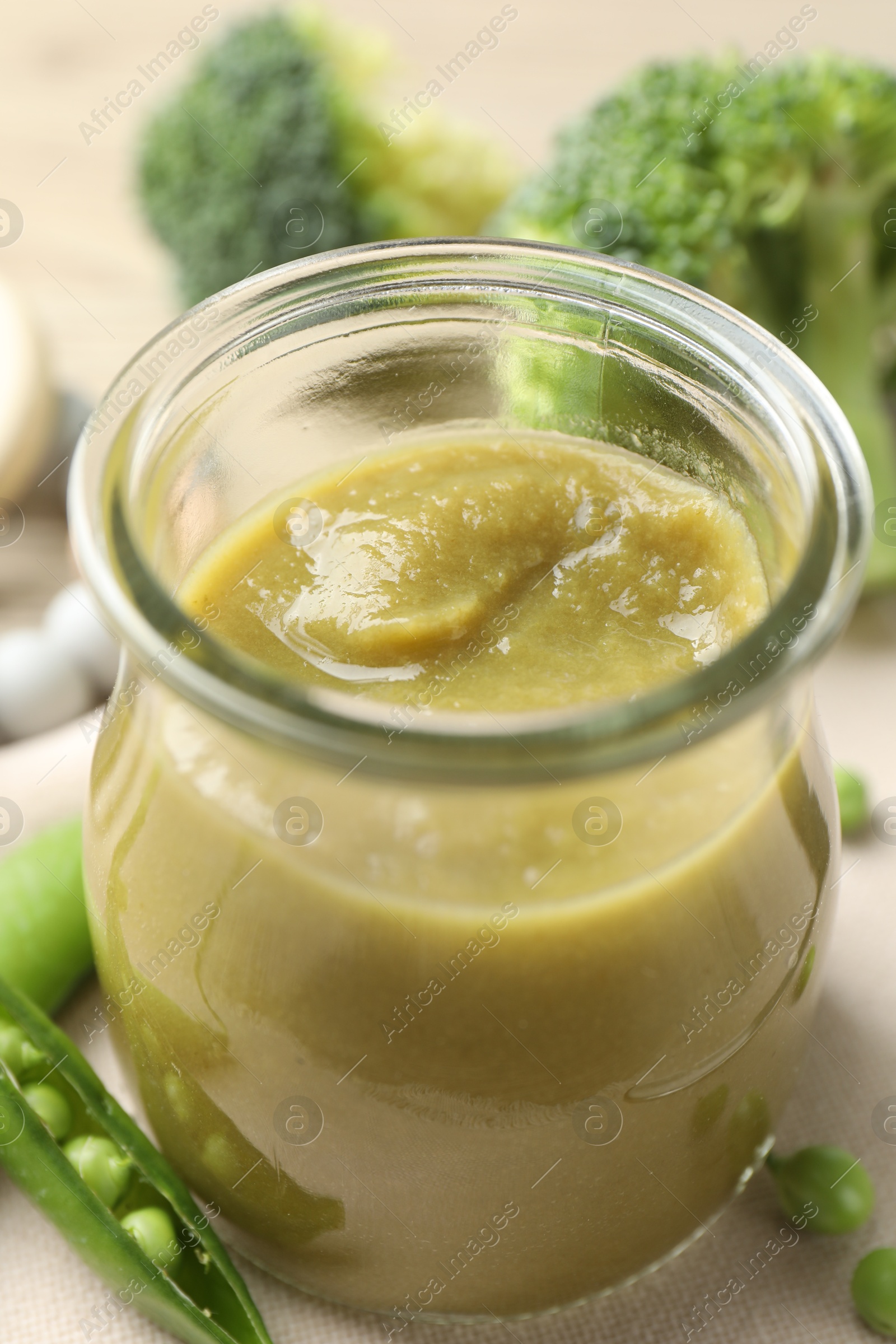 Baby food. Tasty puree in glass jar and ingredients on table, closeup Photo of Baby food. Tasty puree in glass jar and ingredients on table, closeup